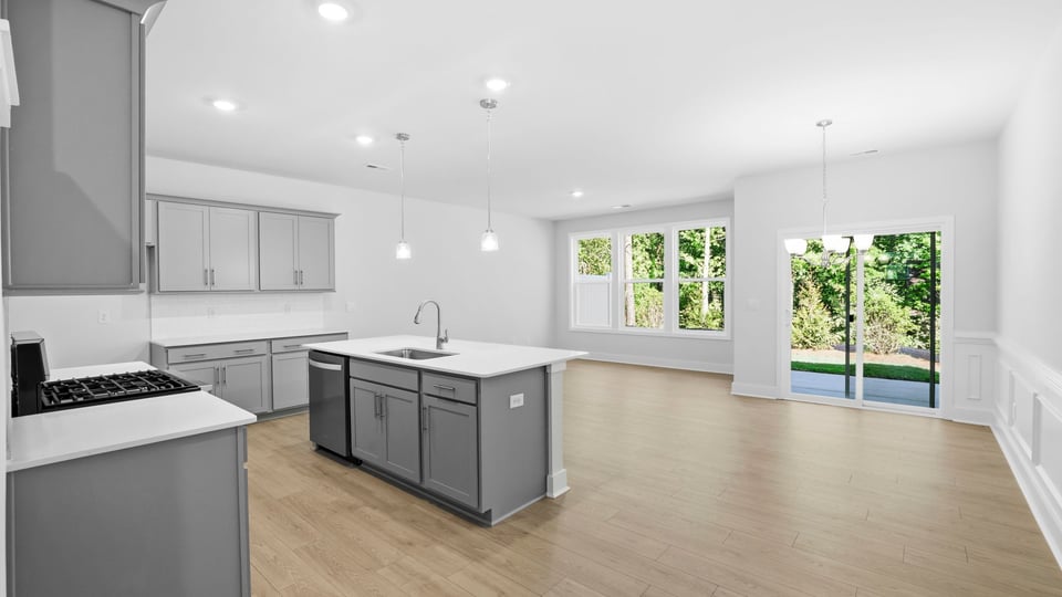 Kitchen and island with quartz countertops and stainless steel appliances.