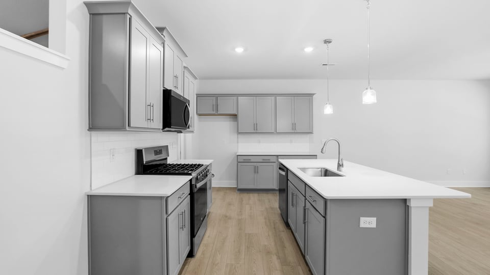 Kitchen and island with quartz countertops and stainless steel appliances.