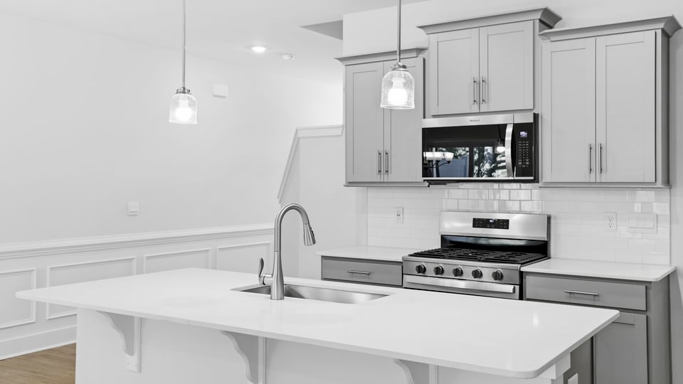 Kitchen and island with quartz countertops and stainless steel appliances.