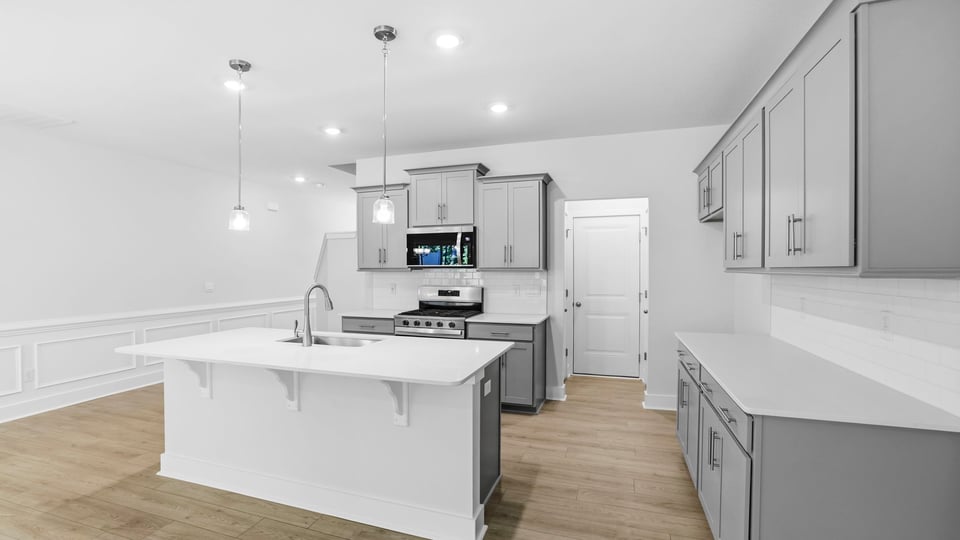 Kitchen and island with quartz countertops and stainless steel appliances.