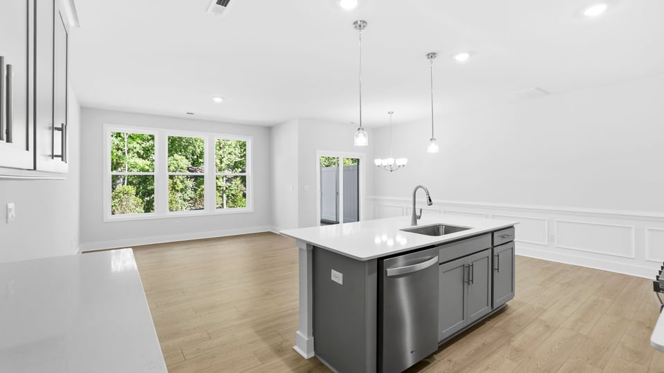 Kitchen and island with quartz countertops and stainless steel appliances.