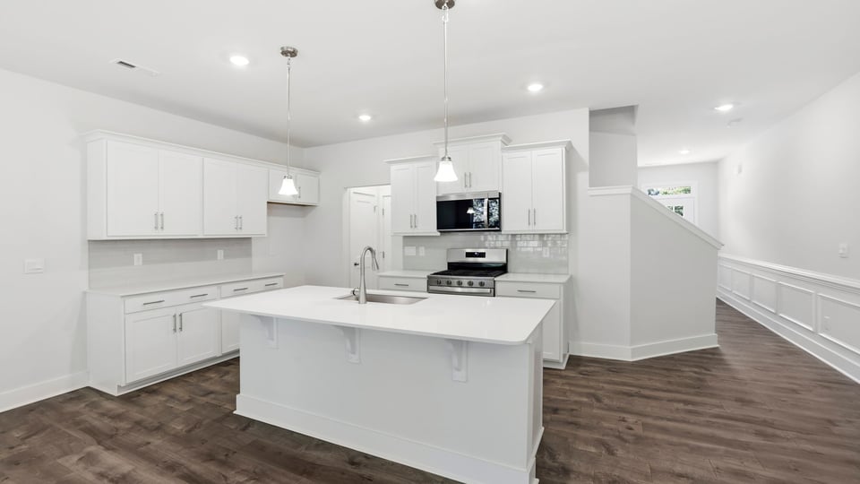 Kitchen and island with quartz countertops and stainless steel appliances.
