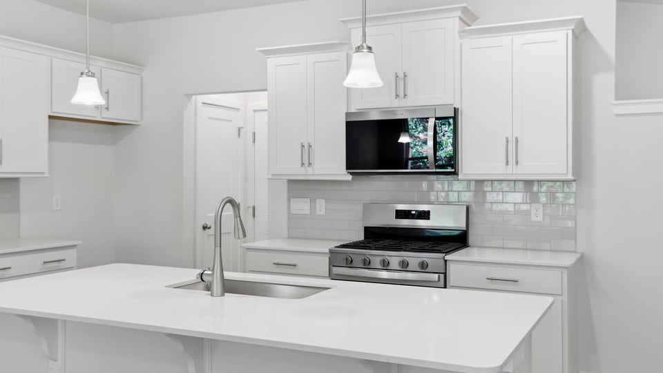 Kitchen and island with quartz countertops and stainless steel appliances.