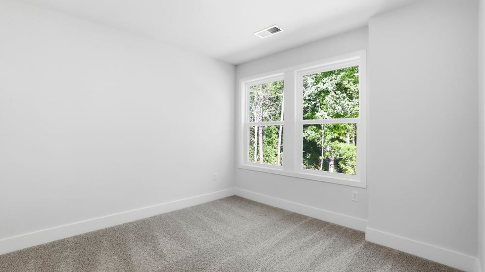 Bedroom with carpet and windows.