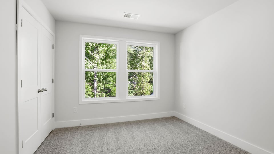 Bedroom with carpet and windows.