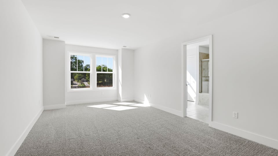 Bedroom with carpet and windows.
