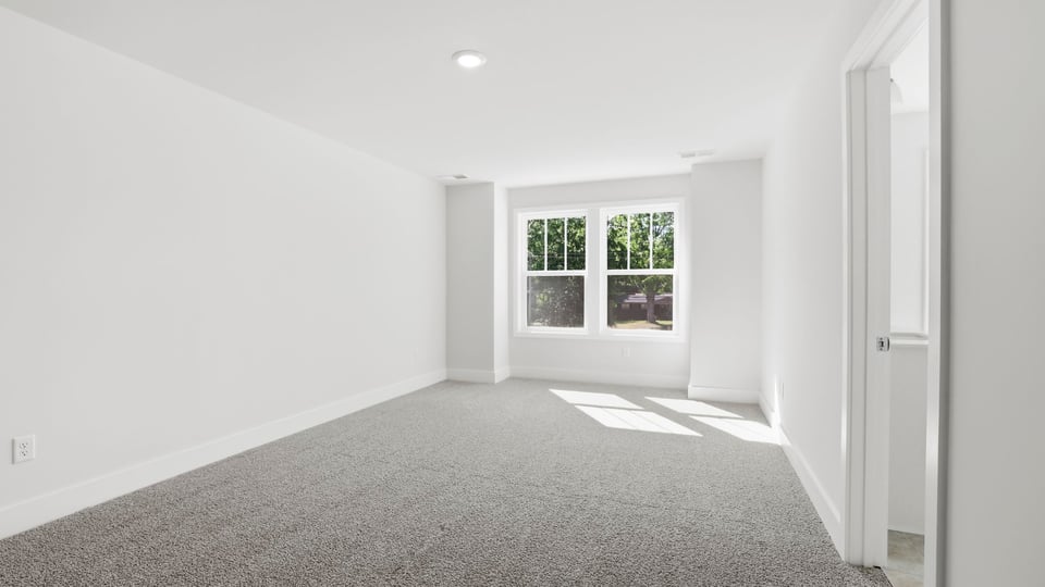 Bedroom with carpet and windows.