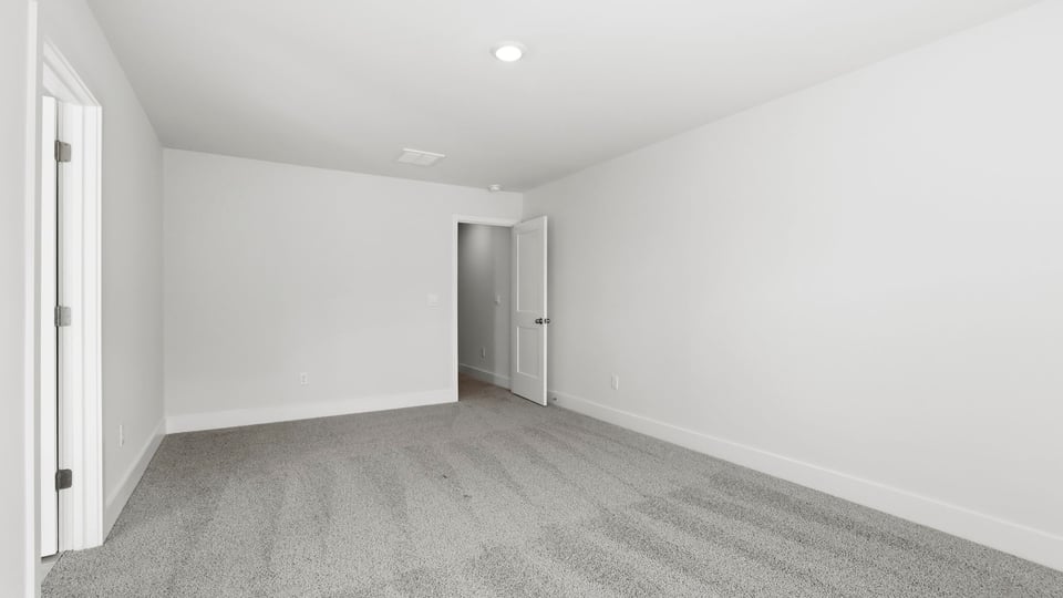 Bedroom with carpet and windows.