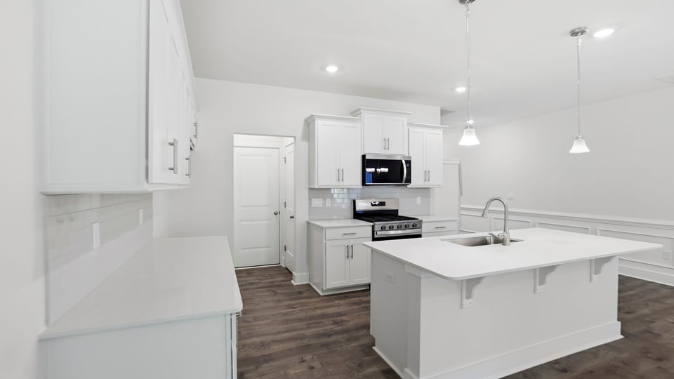 Kitchen and island with quartz countertops and stainless steel appliances.