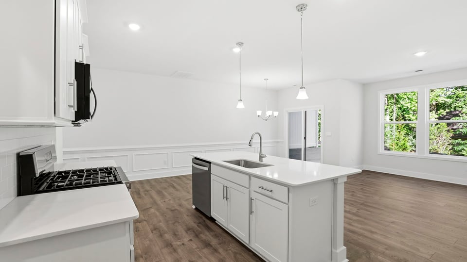 Kitchen and island with quartz countertops and stainless steel appliances.