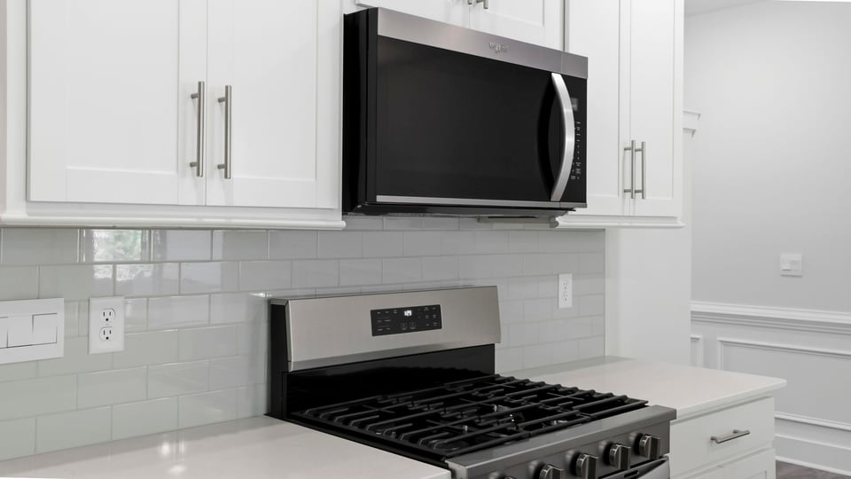 Kitchen and island with quartz countertops and stainless steel appliances.
