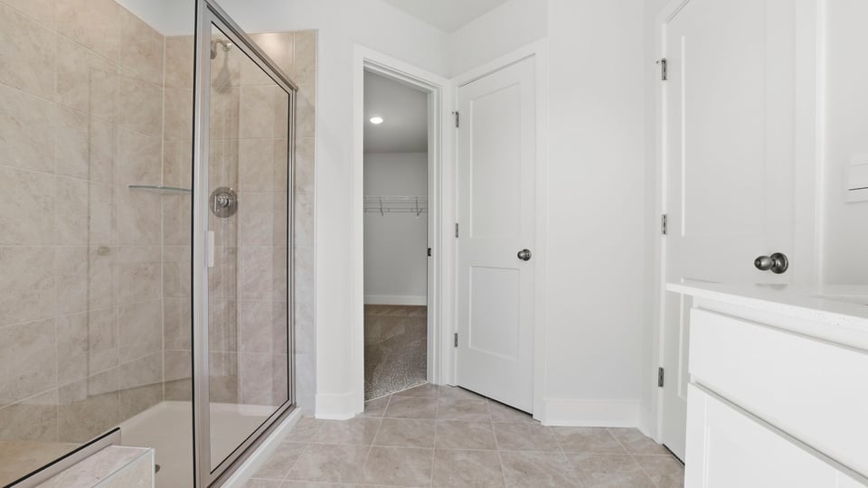 Bathroom with walk in shower and closet.