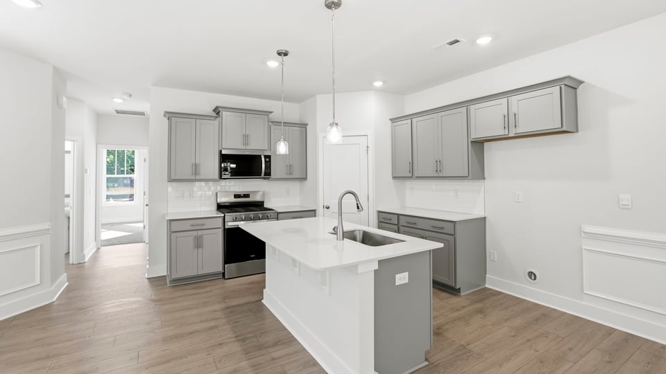 Kitchen and island with quartz countertops and stainless steel appliances.