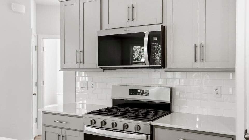 Kitchen and island with quartz countertops and stainless steel appliances.