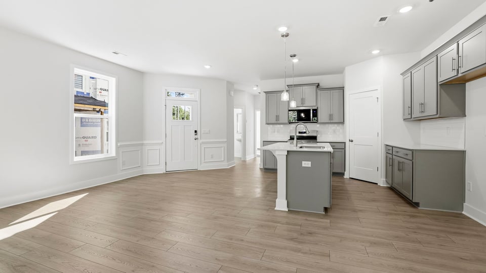 Kitchen and island with quartz countertops and stainless steel appliances.
