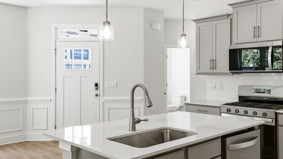 Kitchen and island with quartz countertops and stainless steel appliances.