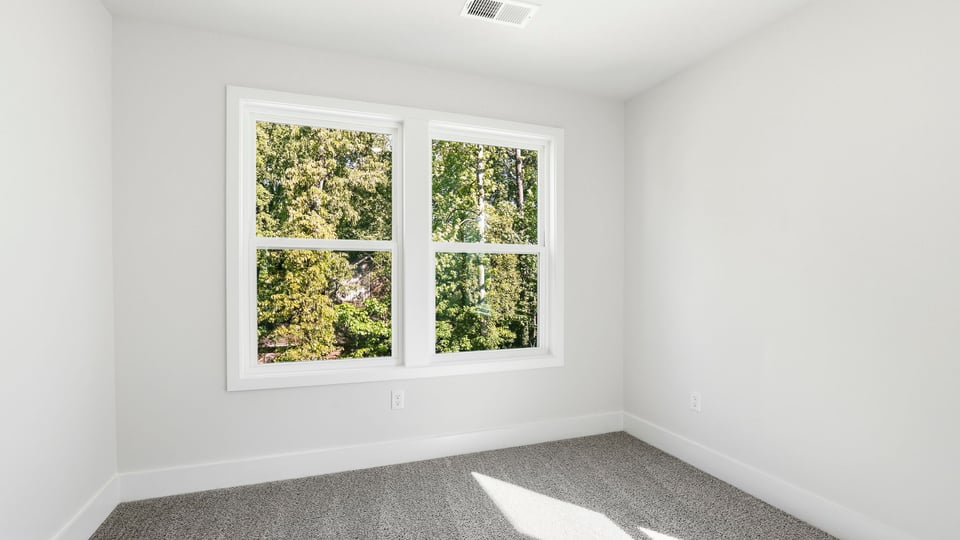 Bedroom with carpet and window.