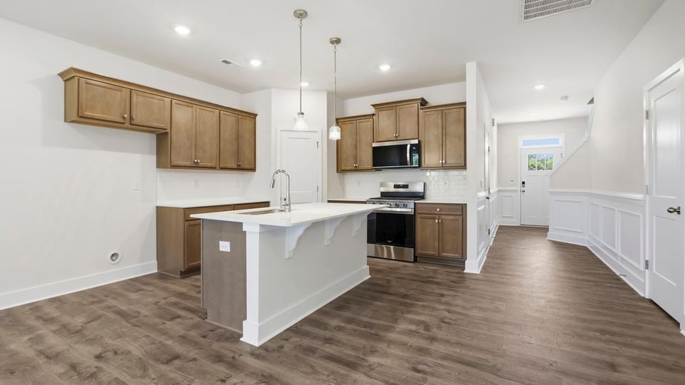 Kitchen and island with stainless steel appliances.