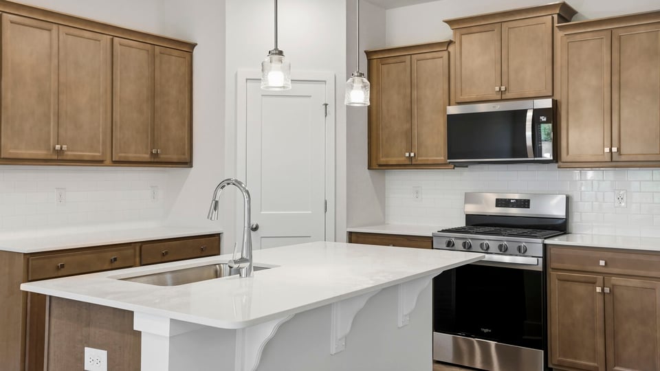 Kitchen and island with stainless steel appliances.