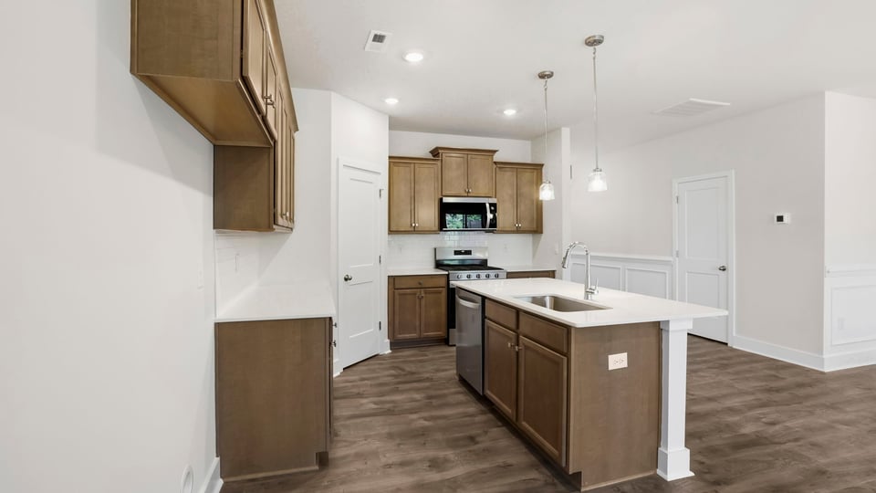 Kitchen and island with stainless steel appliances.