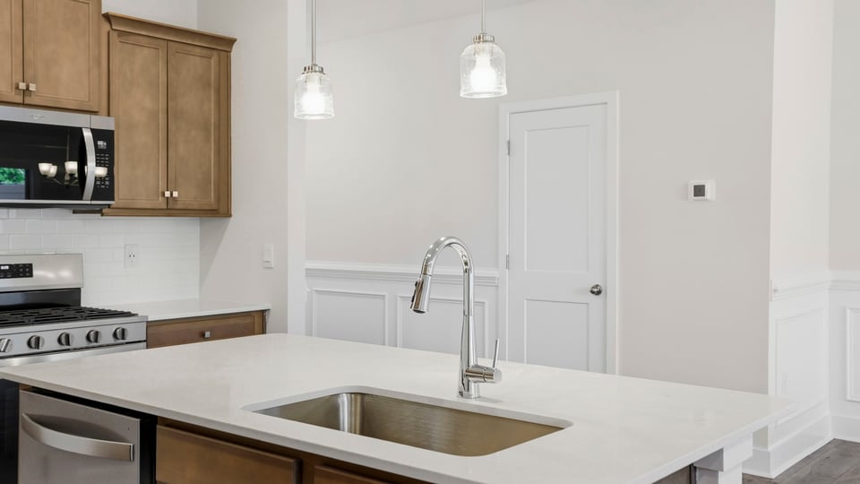 Kitchen and island with stainless steel appliances.