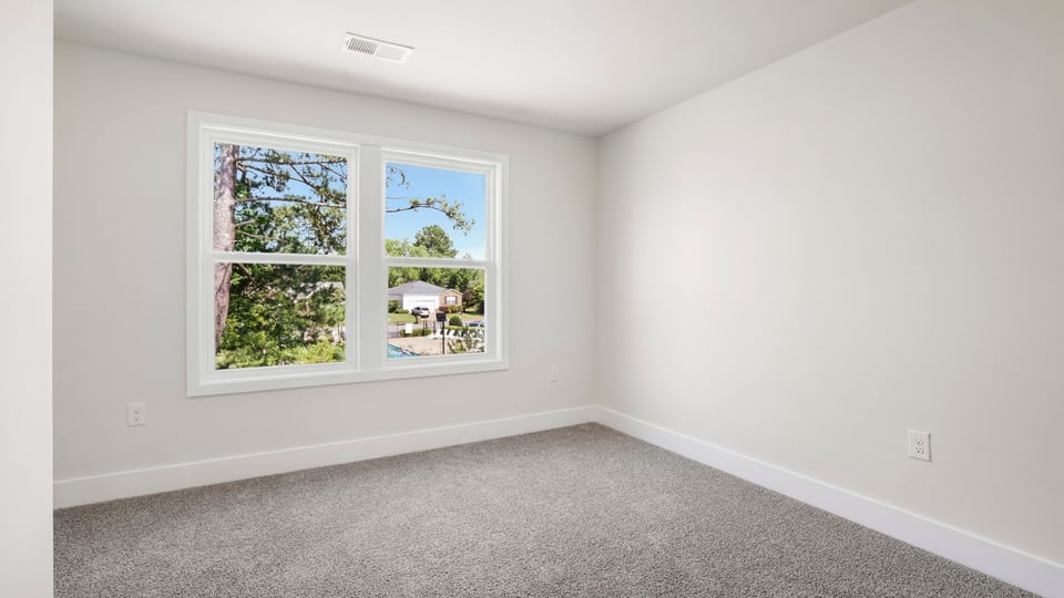 Bedroom with carpet and window.