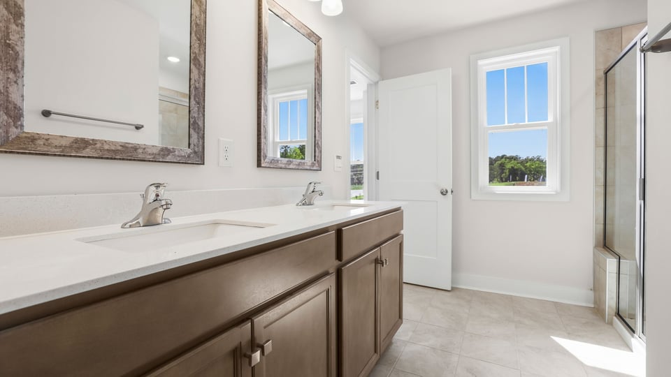 Bathroom with double vanity sink and walk in shower.