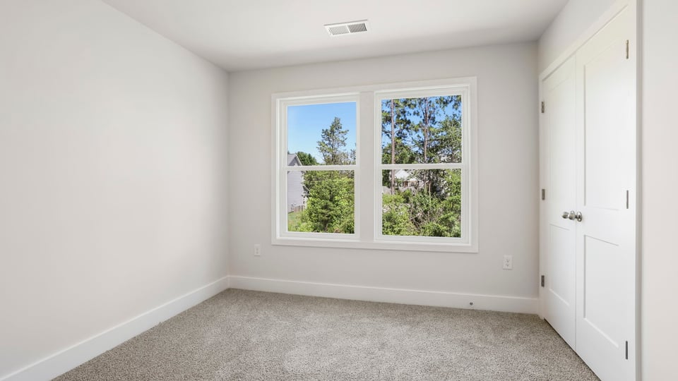 Bedroom with carpet and window.