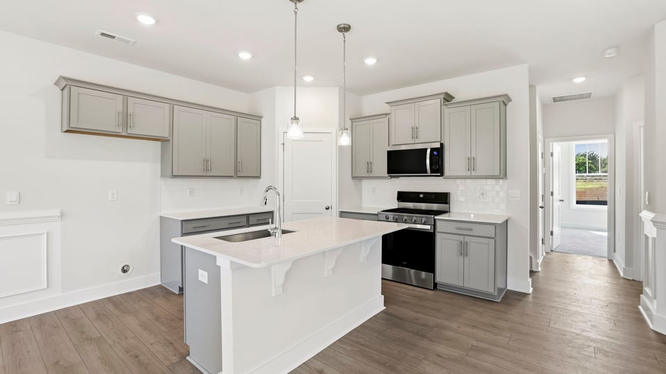 Kitchen and island with stainless steel appliances.
