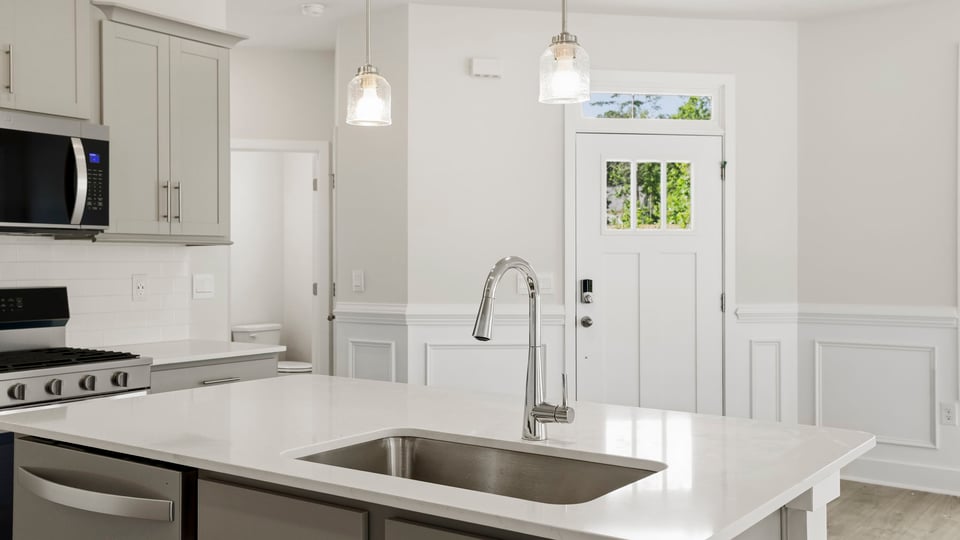 Kitchen and island with stainless steel appliances.