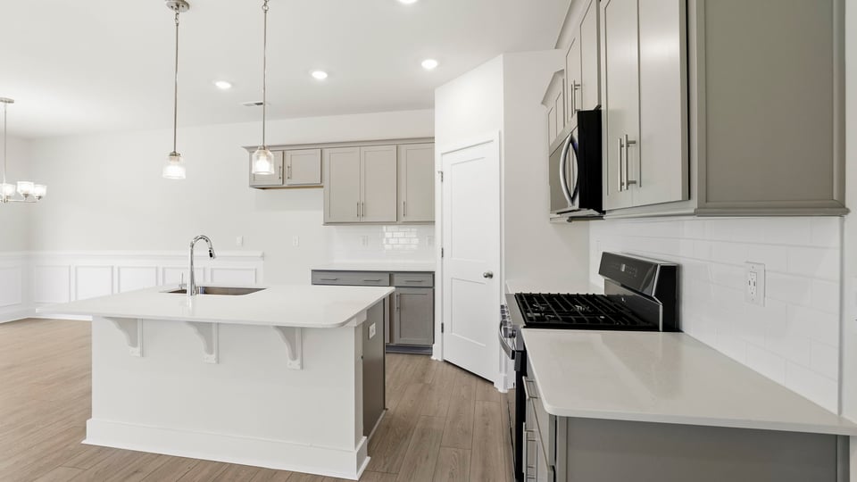 Kitchen and island with stainless steel appliances.