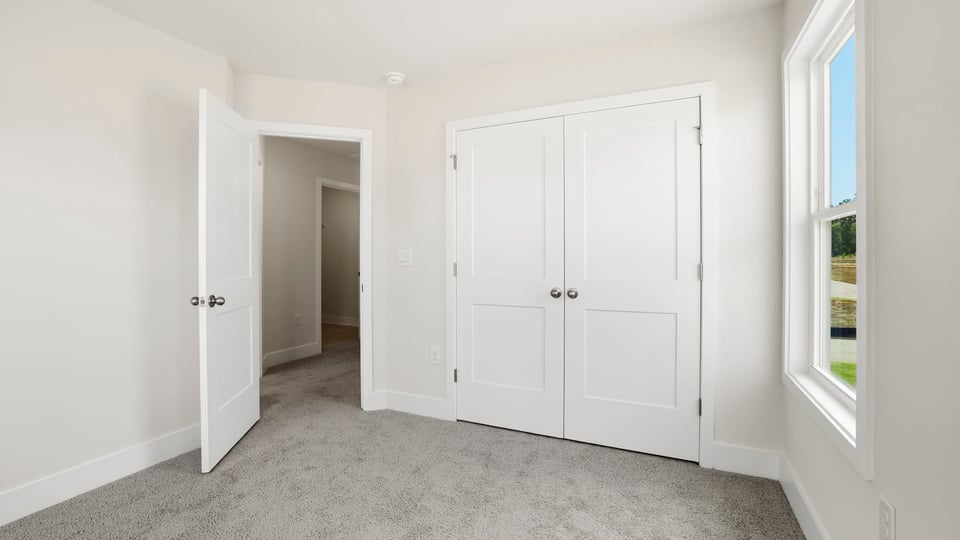 Bedroom with carpet and window.