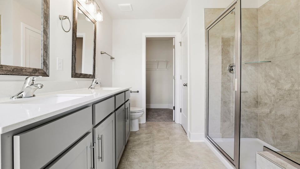 Bathroom with double vanity sink and walk in shower.