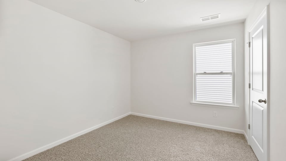 Bedroom with carpet and windows.