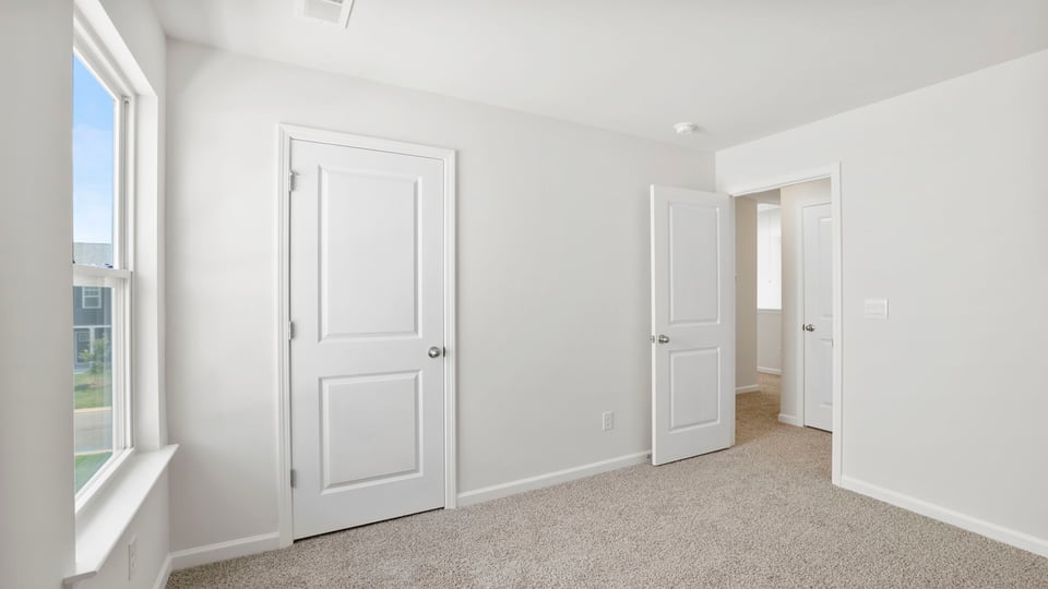 Bedroom with carpet and windows.