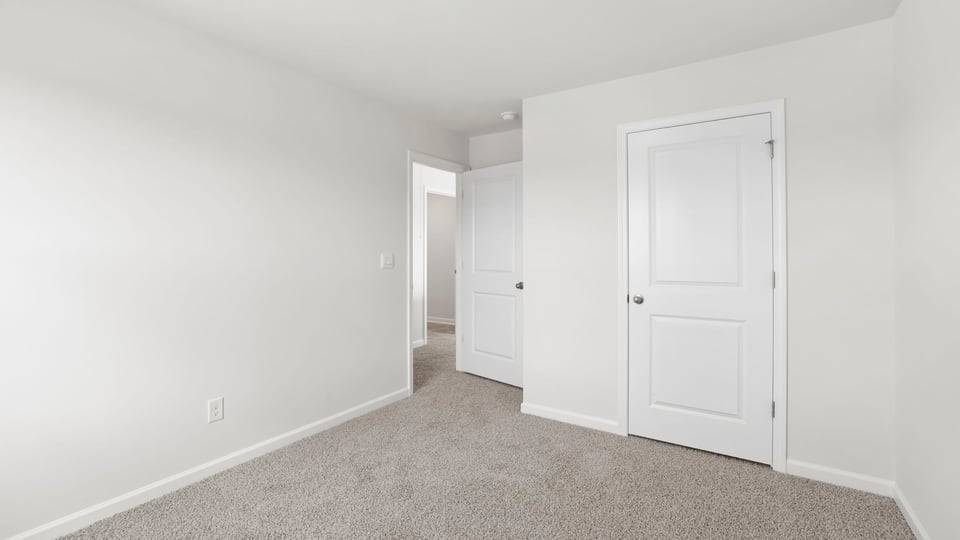 Bedroom with carpet and windows.
