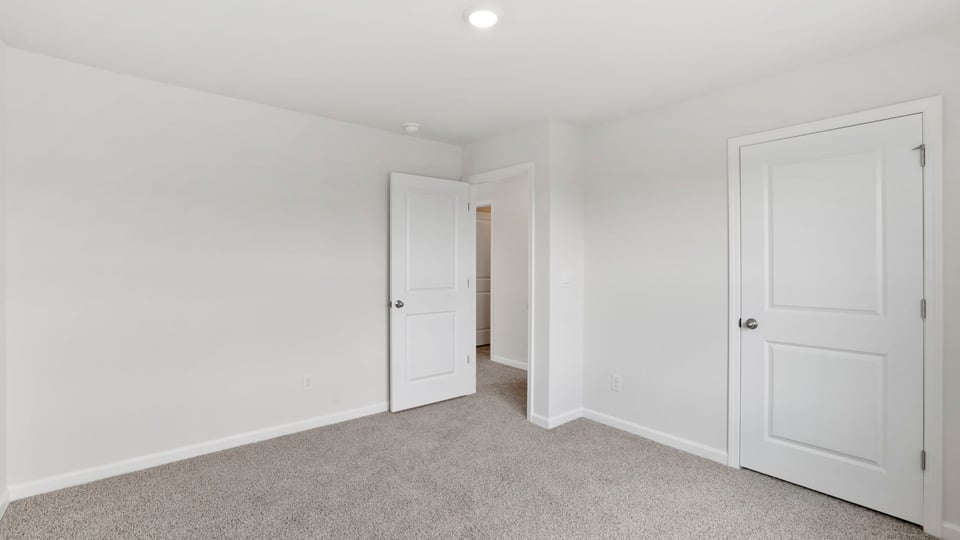 Bedroom with carpet and windows.