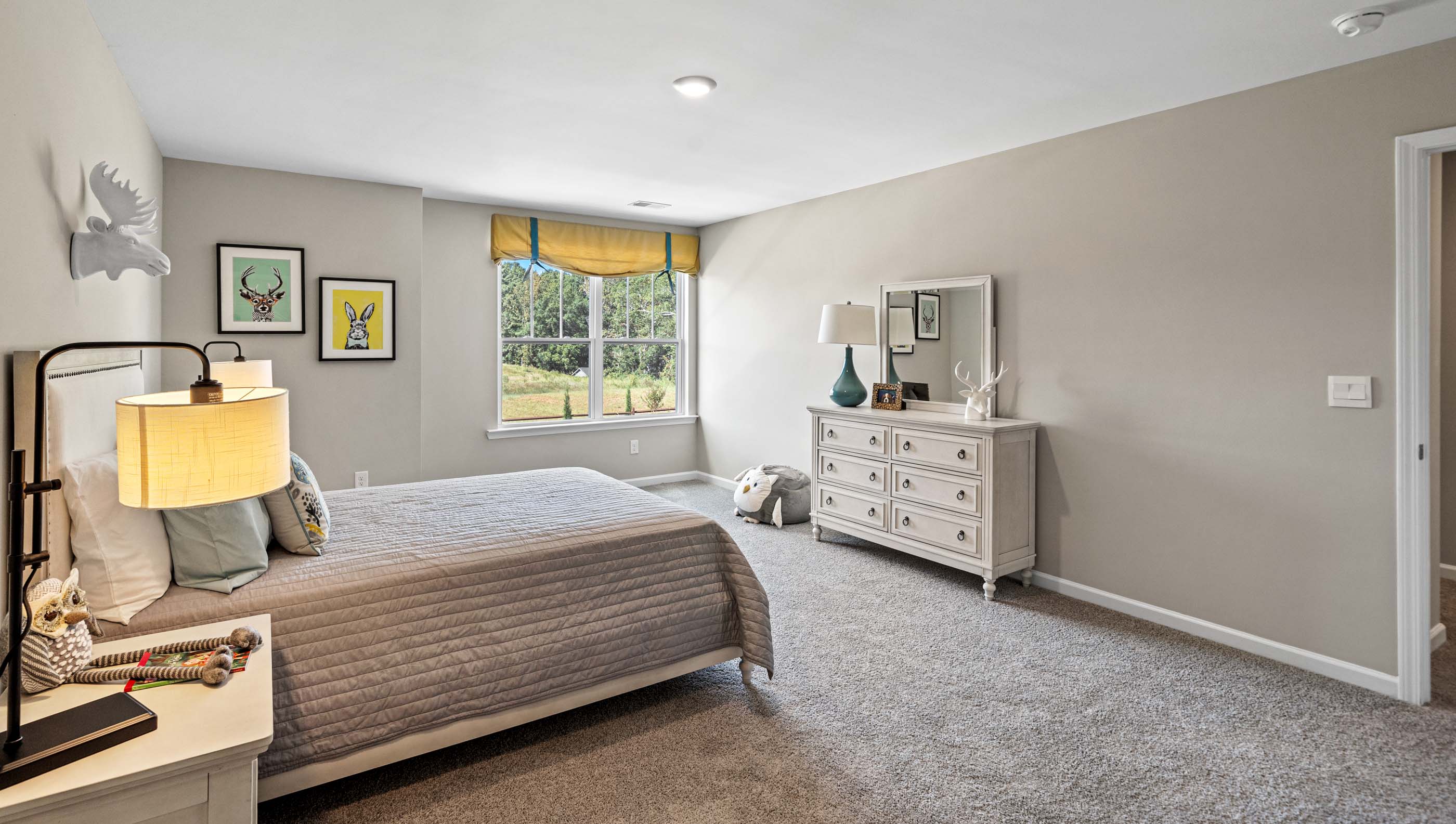 Primary bedroom with carpet and windows.