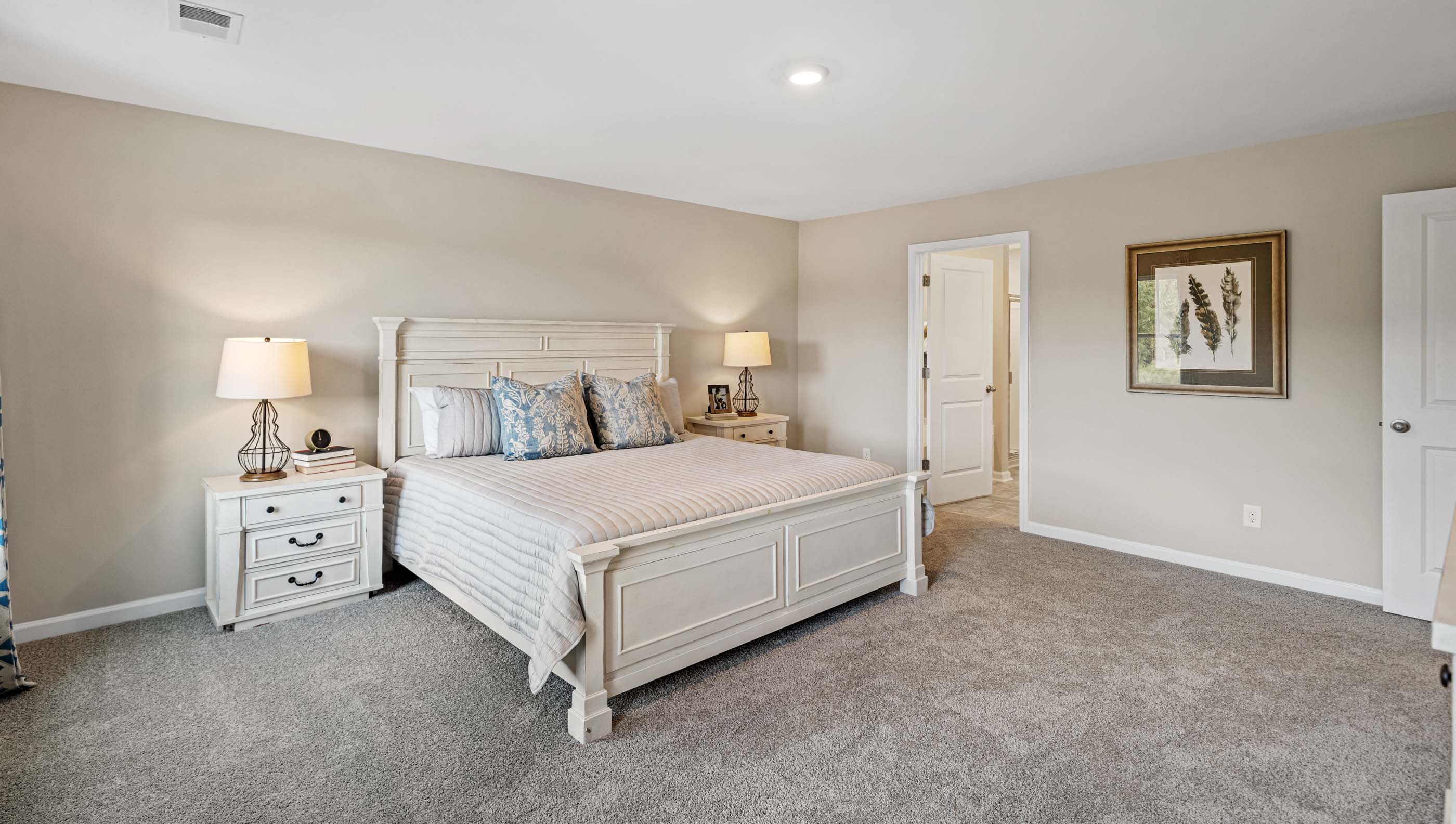 Primary bedroom with carpet and windows.