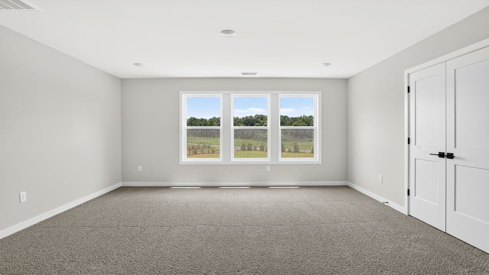 Loft area with windows and carpet.