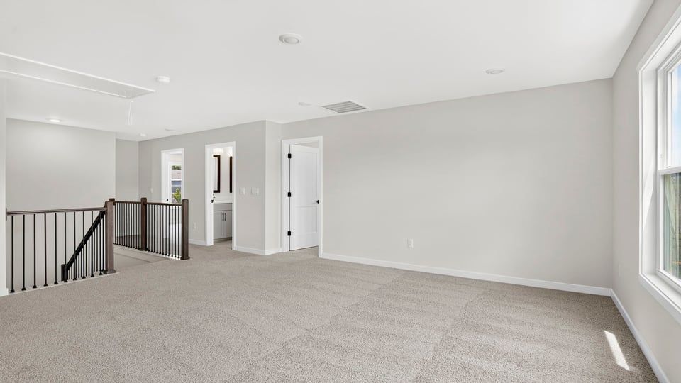 Loft area with windows and carpet.
