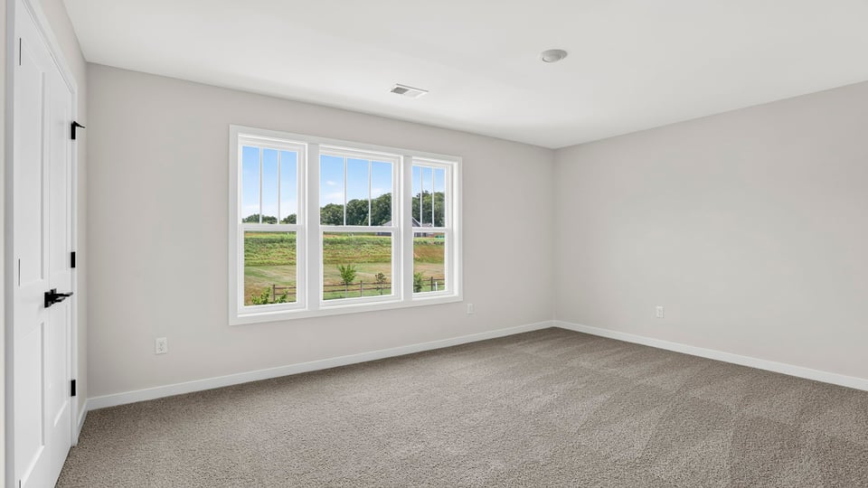 Bedroom with windows and carpet.