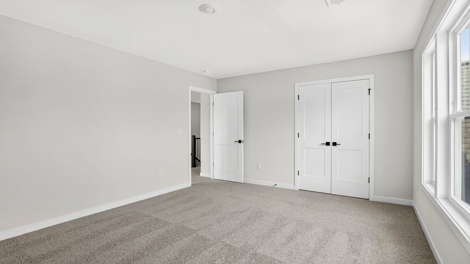 Bedroom with windows and carpet.