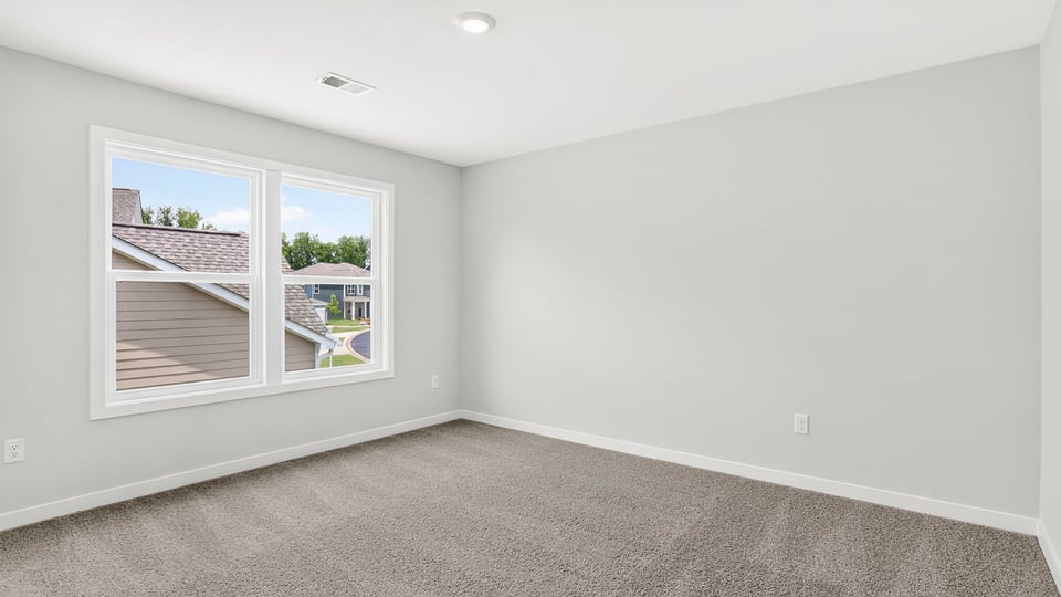 Bedroom with windows and carpet.