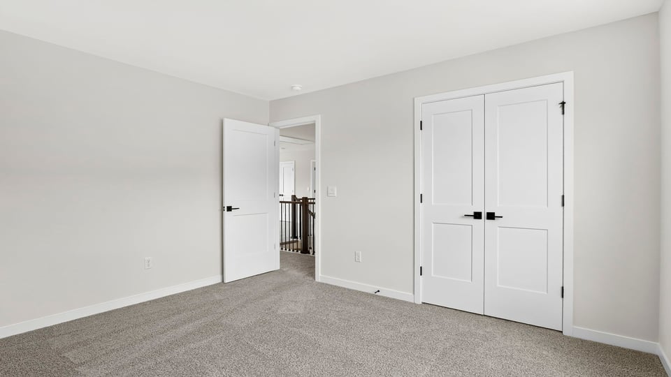 Bedroom with windows and carpet.