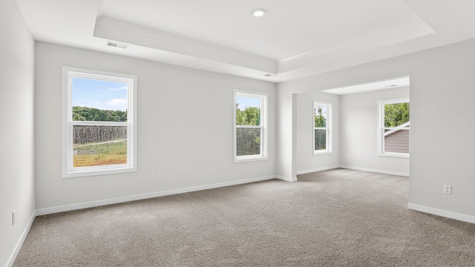 Primary bedroom with window and carpet.