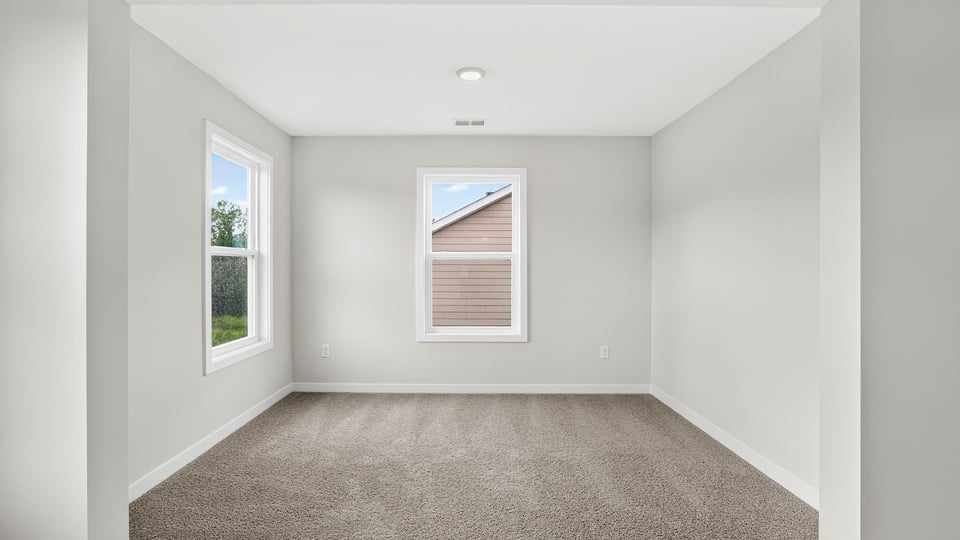 Primary bedroom with window and carpet.