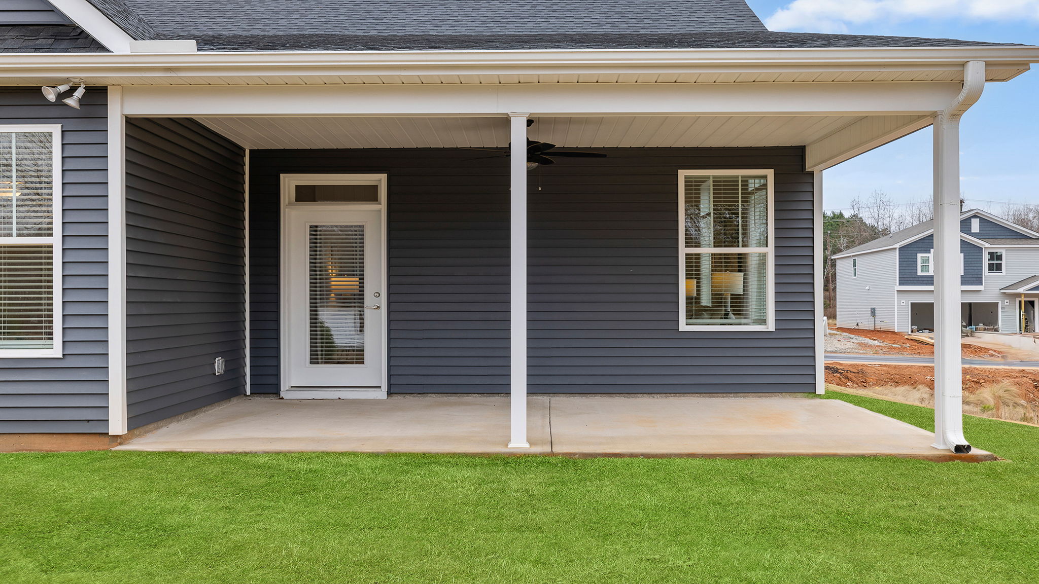 Back exterior with patio and large backyard.