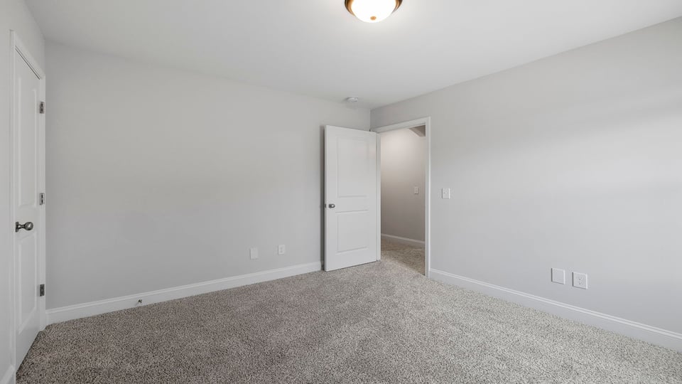 Bedroom with carpet and windows.