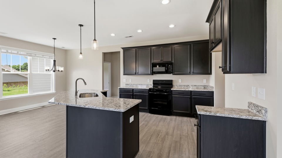 Kitchen and island with stainless steel appliances.